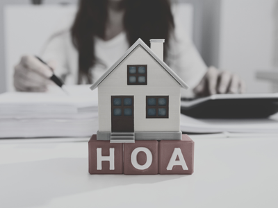 Graphic showing the letters ‘HOA’ with a house icon on top, representing homeowners association fees as part of homeownership costs.