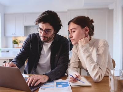 Couple reviewing their mortgage statement and discussing the breakdown of their monthly mortgage payment, including principal, interest, taxes, and insurance.
