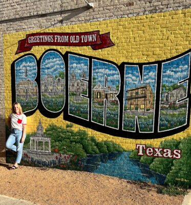 Boerne TX realtor Taryn Pierce in front of the Boerne mural on Main Street.